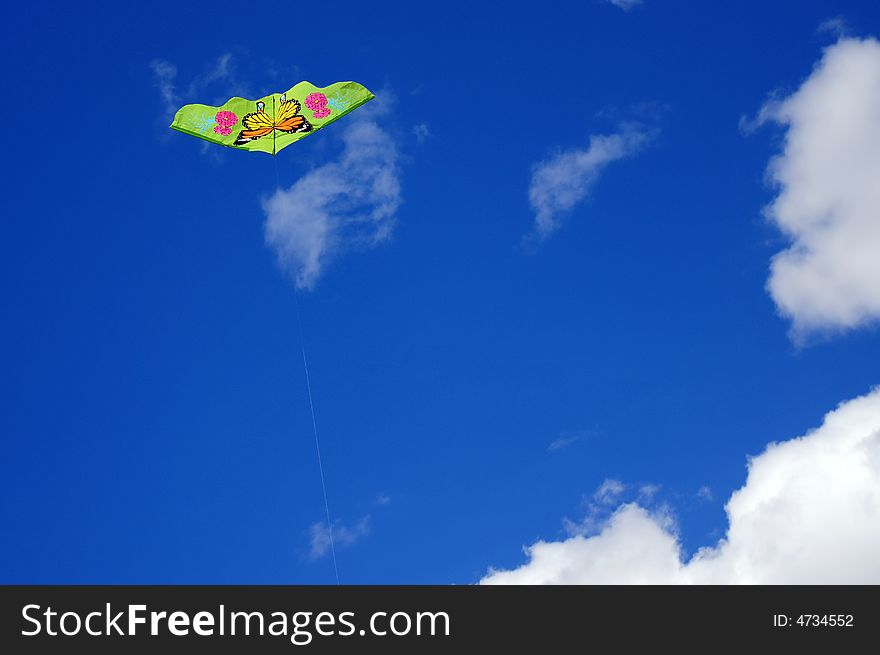 Green kite against blue sky