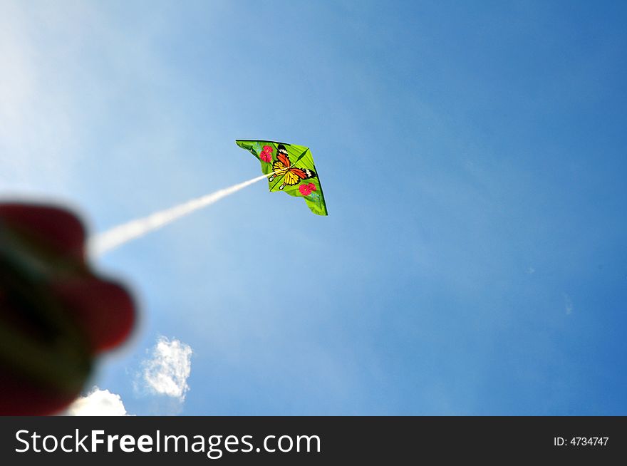 Green kite against blue sky. Green kite against blue sky