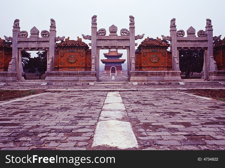 Glazed gate at the qing west tombs. purlins and bracket sets carved out of one piece of stone. the bracket sets and tie beams are engraved with designs of flowers and animals.