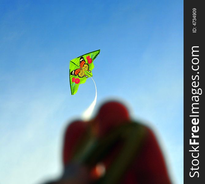 Green kite against blue sky. Green kite against blue sky