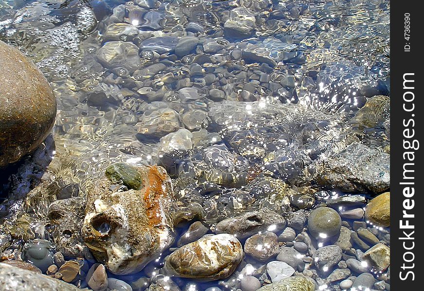 Sea water, pebble. Clear sea water of coast. The stone bottom is visible.