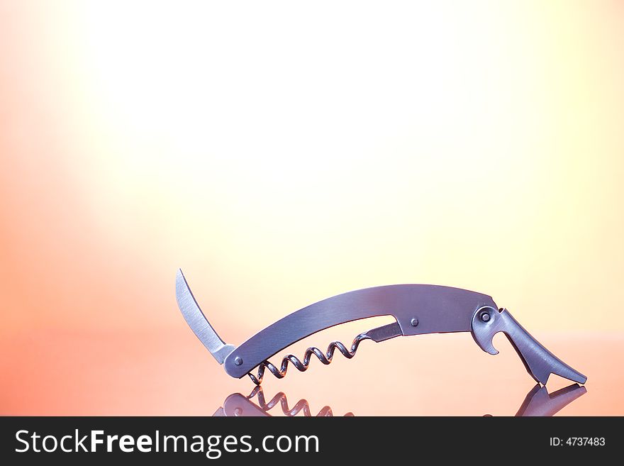 A metal corkscrew on the orange background / copyspace