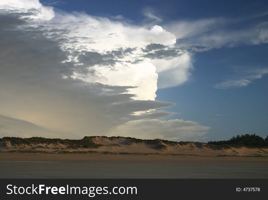Beautiful sandy beach with dramatic clouds on a blue sky. Australia.