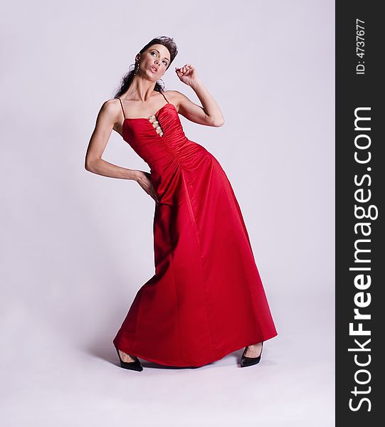 Young woman wearing a red dress, striking a pose. Young woman wearing a red dress, striking a pose