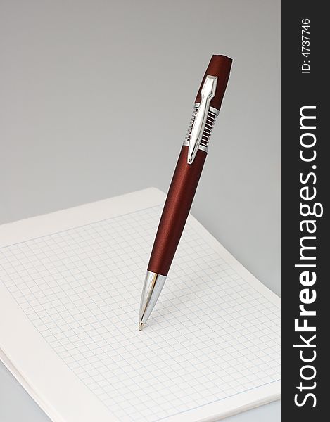 Red ball pen and notebook into check. Red ball pen and notebook into check