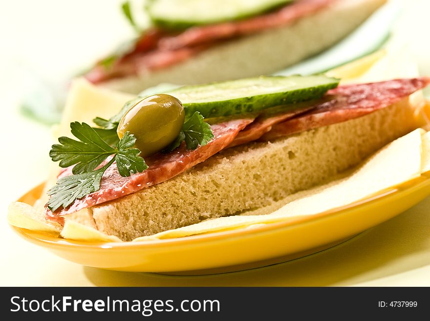 Fresh sandwich with salami, cucumber and olive