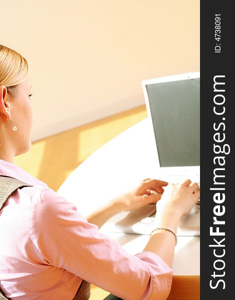 A successful business woman is working on a table with a laptop