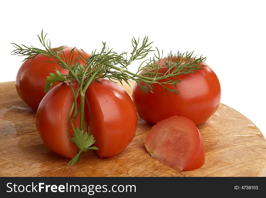 Three tomatoes with fennel on table