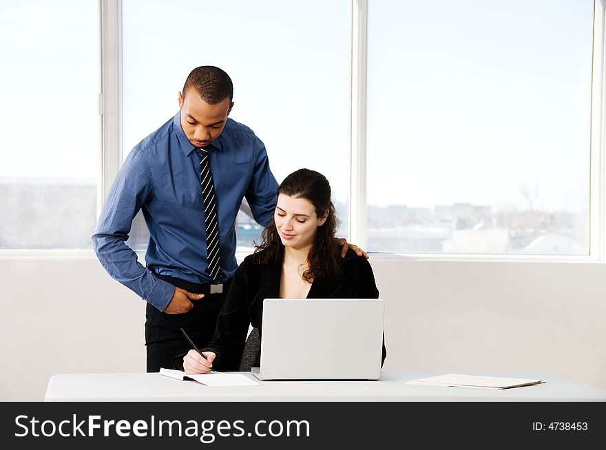 Male and female business partners in a window office. Male and female business partners in a window office