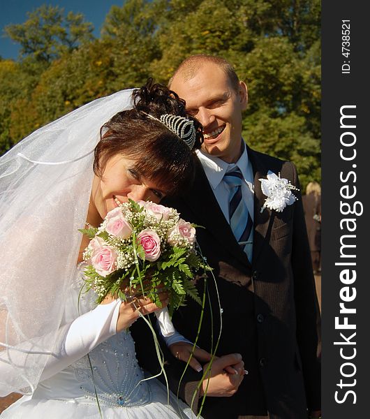 Newly wedded couple walking on the park