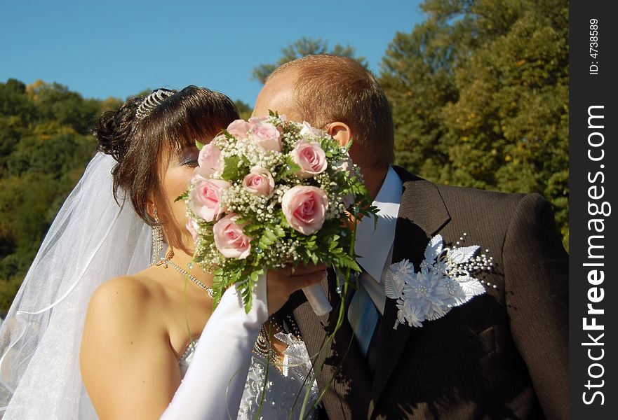 Portrait of the a newly wedded couple kissing