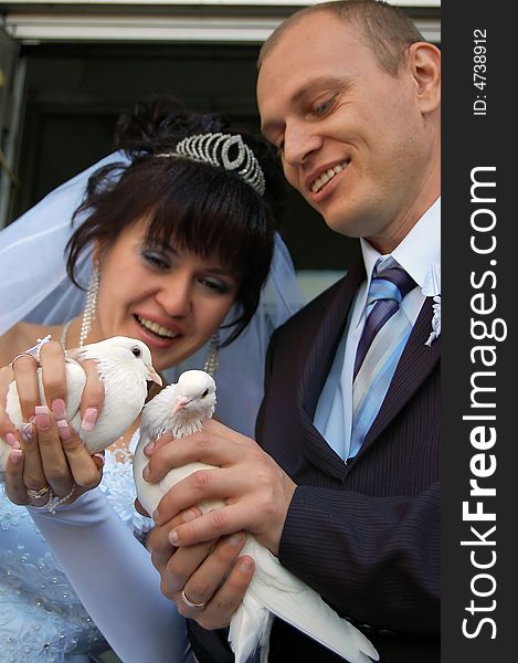 Newly wedded couple playing with doves. Newly wedded couple playing with doves