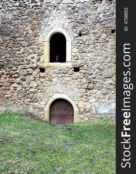 Old stone wall with bricks and windows. Old stone wall with bricks and windows