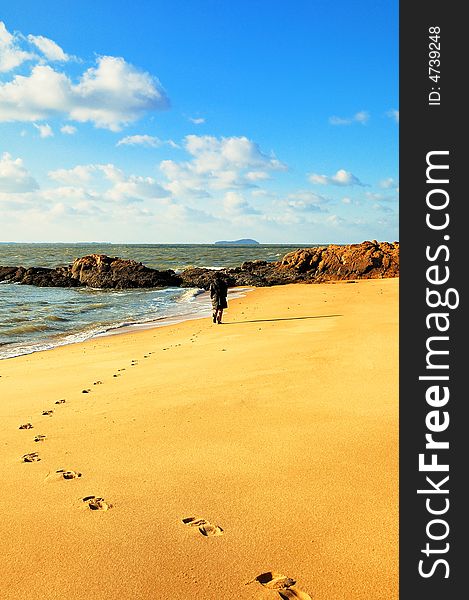 The setting sun of winter , one woman had been visited from the sandy beach , have left a string of footmark.