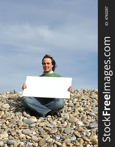 Young Man Holding White Card at the beach