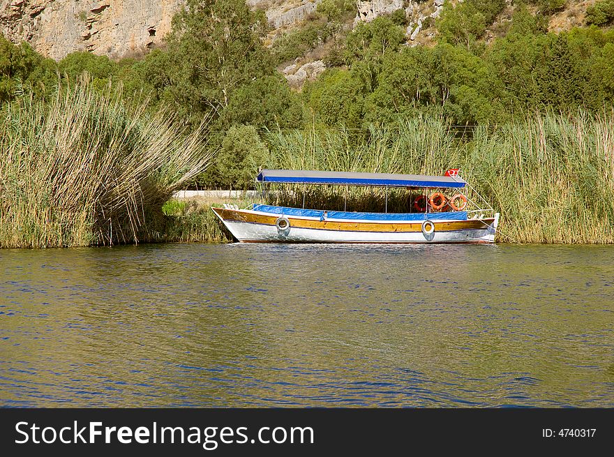 Fishing boat moored near reeds on the river coast