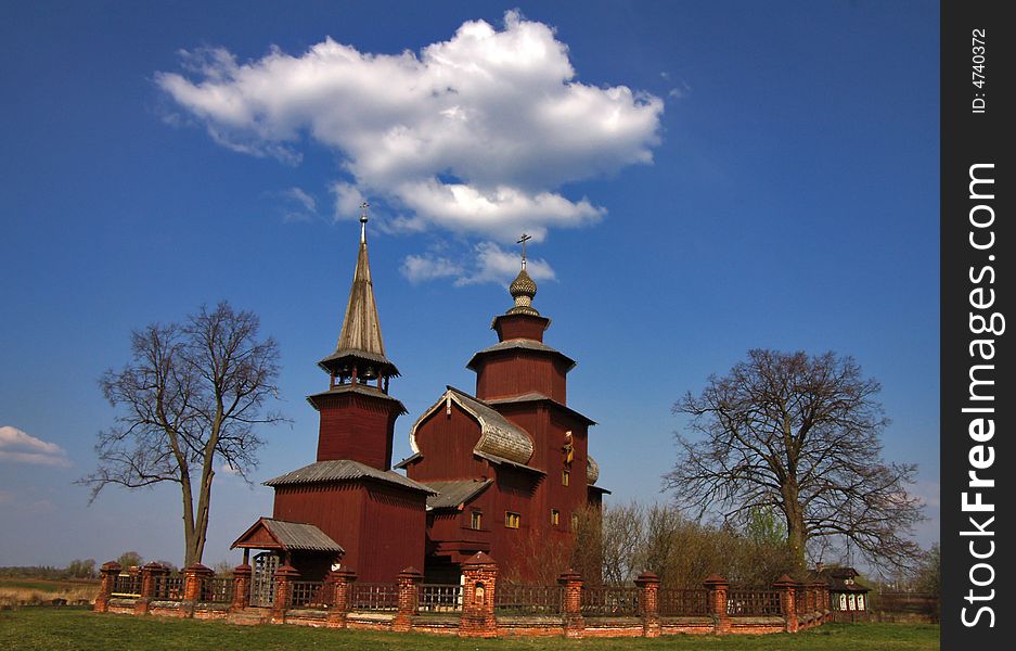 Wooden church on a background of the blue sky with a cloud. Wooden church on a background of the blue sky with a cloud.
