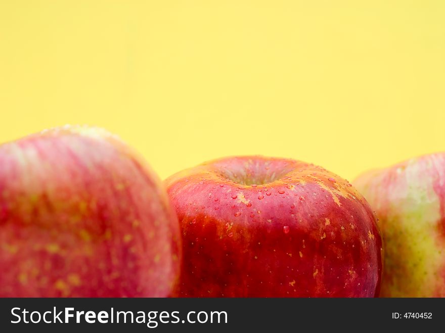 Fresh red apples on a bright yellow background with shallow focus. Fresh red apples on a bright yellow background with shallow focus