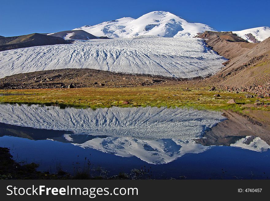 Reflection of mountain Elbrus and glacier descending from it.