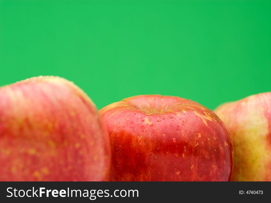 Fresh red apples on a bright green background with shallow focus. Fresh red apples on a bright green background with shallow focus