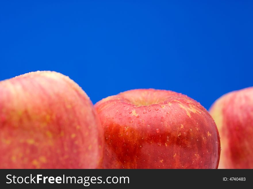 Fresh red apples on a bright blue background with shallow focus. Fresh red apples on a bright blue background with shallow focus