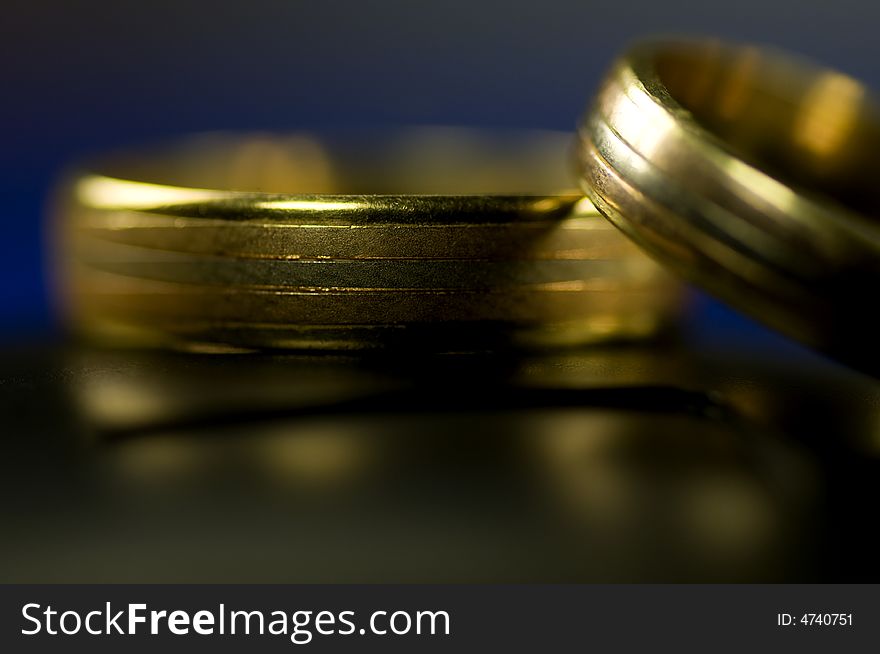 Two golden rings on black with blue background