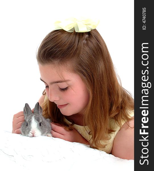 School aged girl gently petting soft gray bunny. School aged girl gently petting soft gray bunny