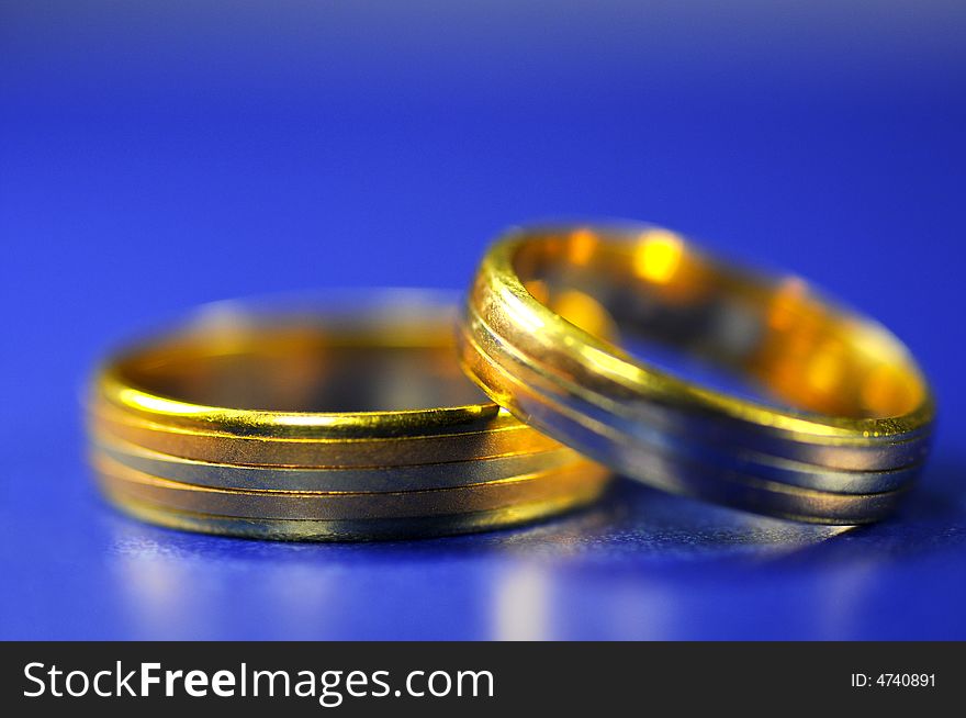 Two golden rings on blue with blue background
