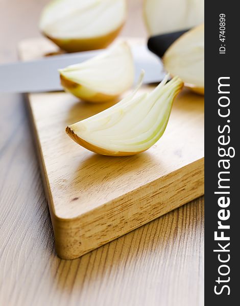 Onion halves with knife on the wooden table. Onion halves with knife on the wooden table