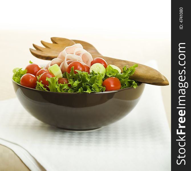 Prosciutto salad with wooden spoon on the table