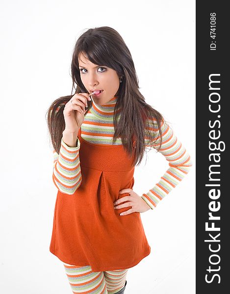 Young brunette girl in orange dress with candy. Young brunette girl in orange dress with candy.