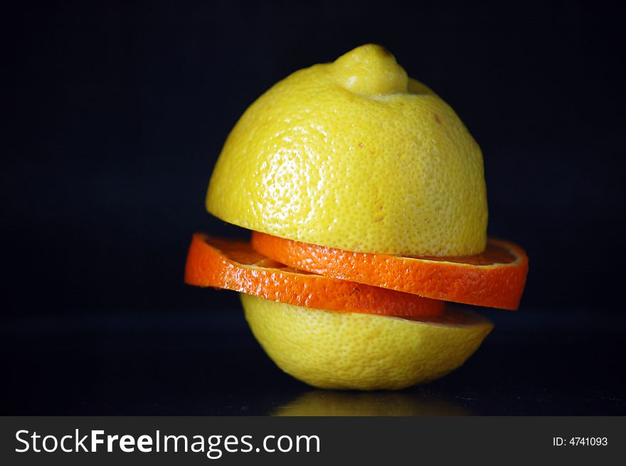 An orange and lemon on black background. An orange and lemon on black background