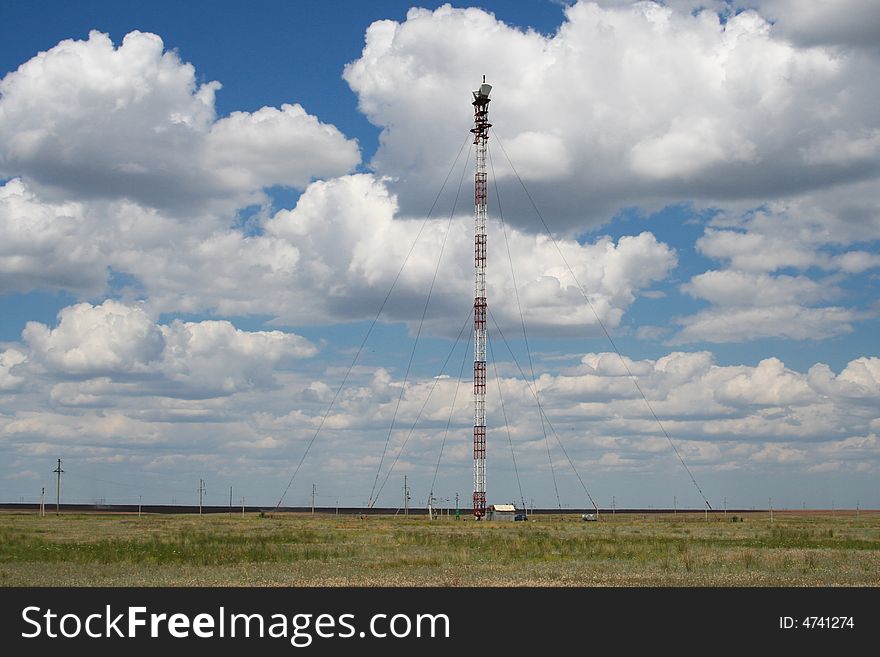 Communication tower on the blue clouds sky. Communication tower on the blue clouds sky