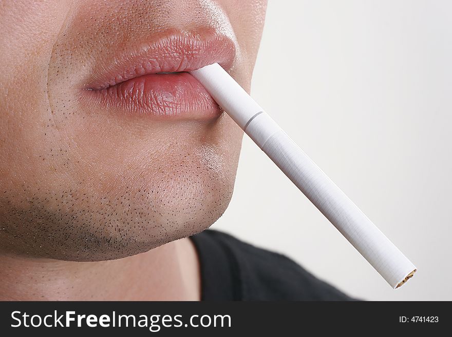 Man holds a cigarette in mouth