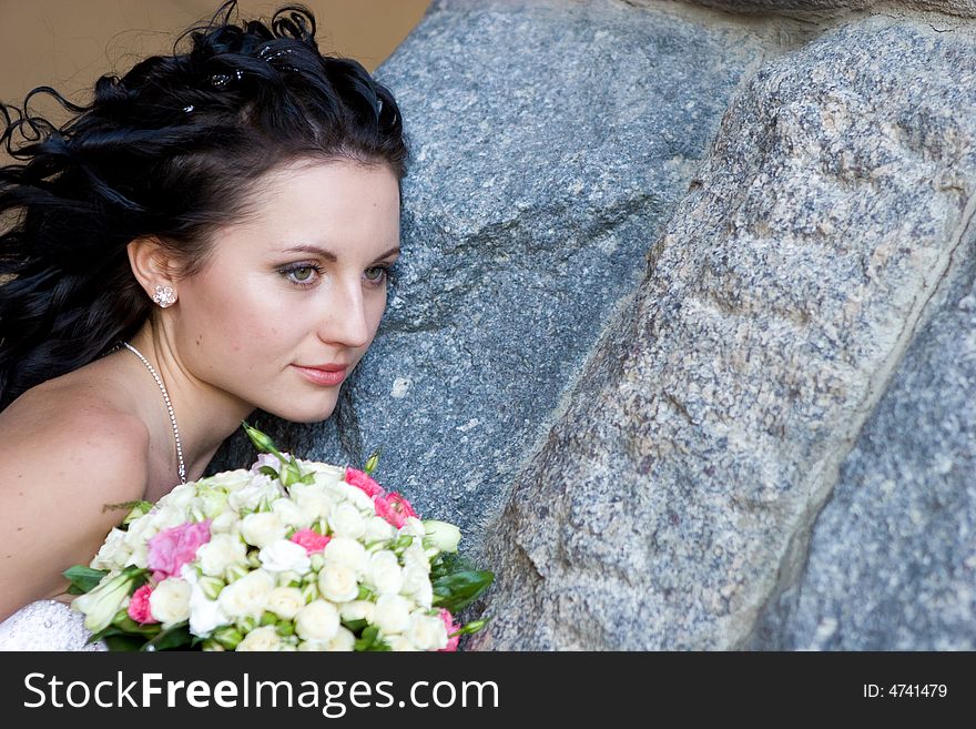 Girl with rose bouquet near the stone wall. Girl with rose bouquet near the stone wall