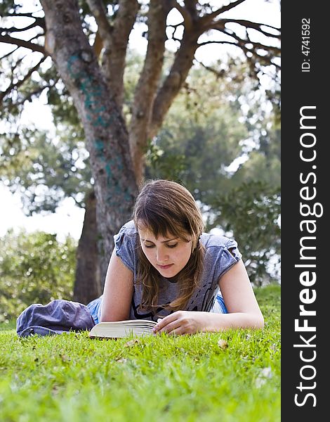 Young woman reading over the grass. Young woman reading over the grass.