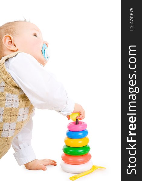 The toddler boy plays developing game. Color pyramidon.