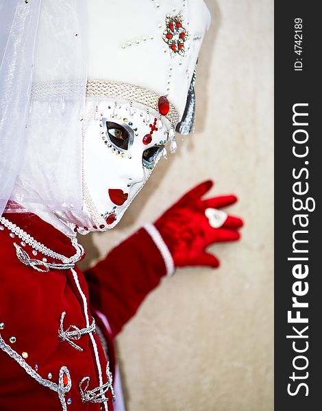 Red velvet costume and a white mask in Venice. Red velvet costume and a white mask in Venice