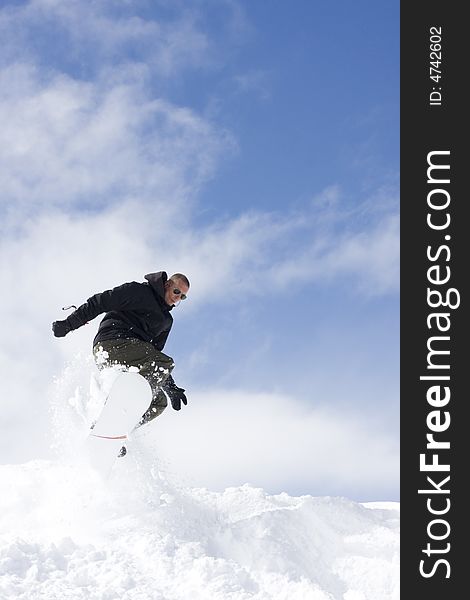 Snowboarder taking a jump in fresh snow