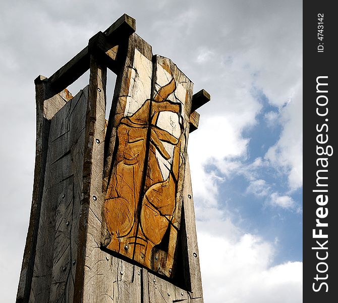 A view with an abstract wood sculpture outdoor representing a hand againts sky. A view with an abstract wood sculpture outdoor representing a hand againts sky