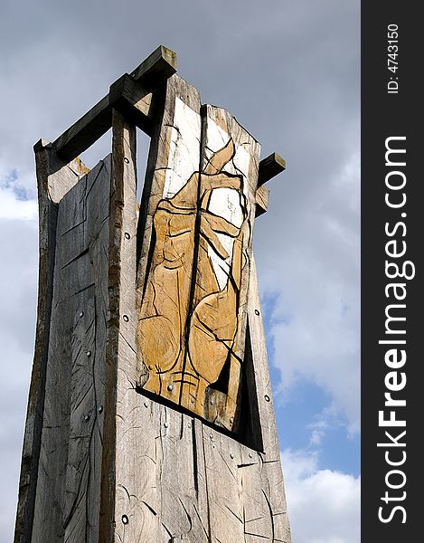 A view with an abstract wood sculpture outdoor representing a hand againts sky. A view with an abstract wood sculpture outdoor representing a hand againts sky