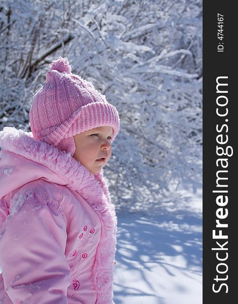 Young girl dressed in pink hat and coat outside in the snow. Young girl dressed in pink hat and coat outside in the snow.