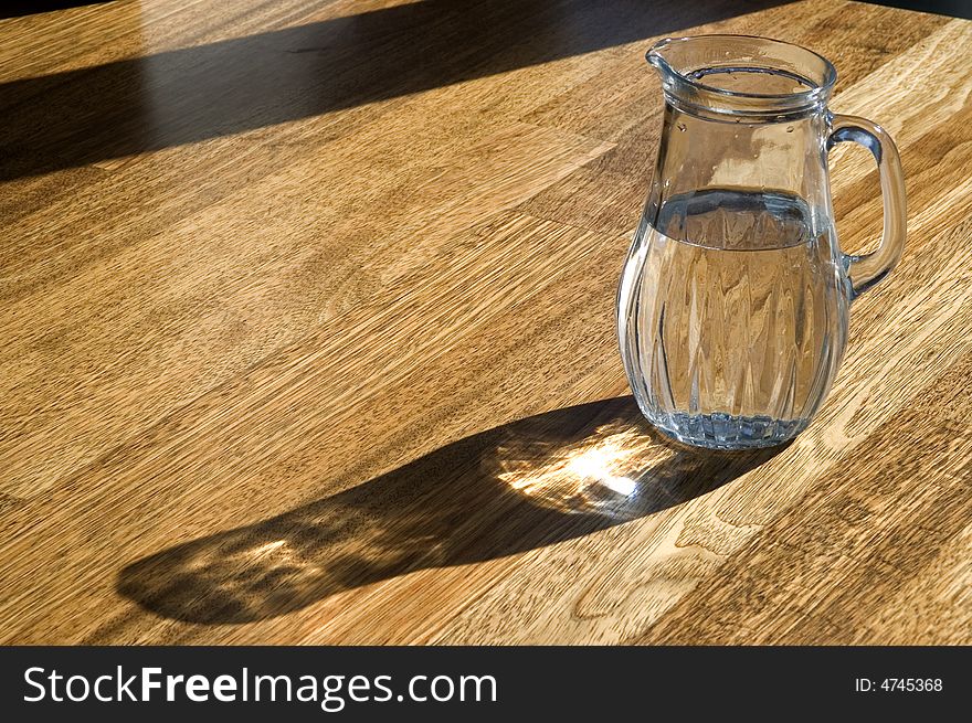 Decanter with water on a wooden floor. Decanter with water on a wooden floor.