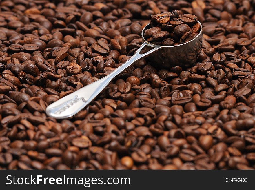 Coffee spoon lying on coffee beans. Coffee spoon lying on coffee beans