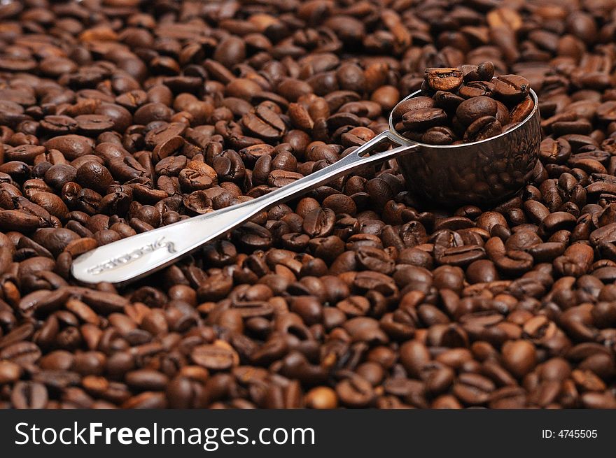 Coffee spoon lying on coffee beans. Coffee spoon lying on coffee beans