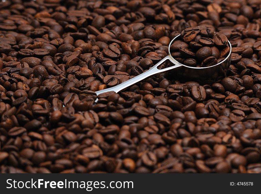 Coffee spoon lying on coffee beans. Coffee spoon lying on coffee beans