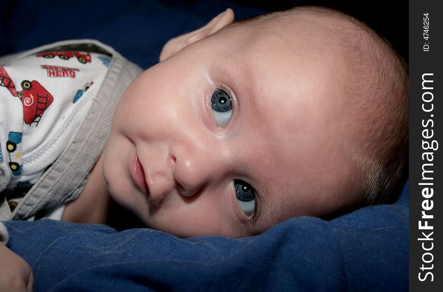 Baby boy laying on his tummy looking up. Baby boy laying on his tummy looking up.