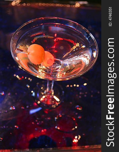 An image of a martini with olives