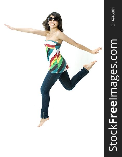 A young beautiful girl in a bright top with sunglasses jumping. A young beautiful girl in a bright top with sunglasses jumping