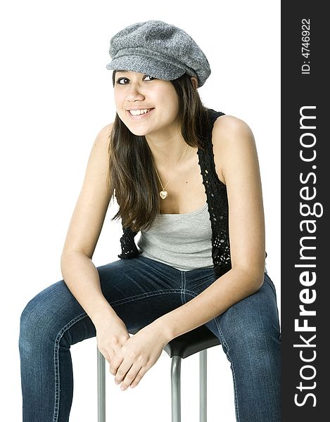 A young beautiful female sitting on a stool wearing a hat. A young beautiful female sitting on a stool wearing a hat